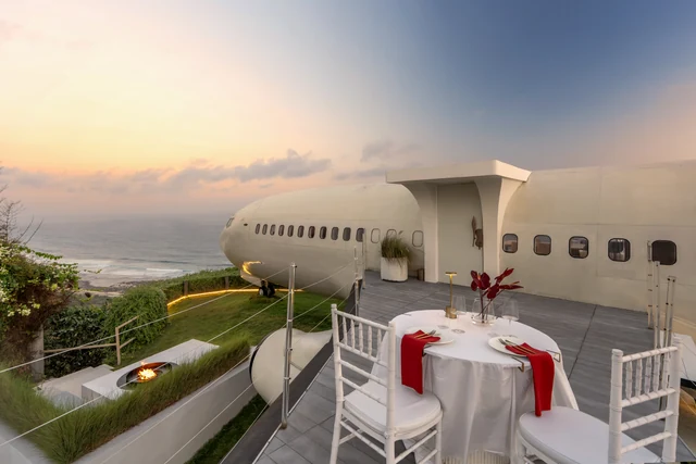 A table set beside the jet at sunset, fire pit lit