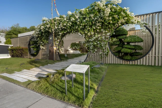 A white flower arch on the ceremony lawn