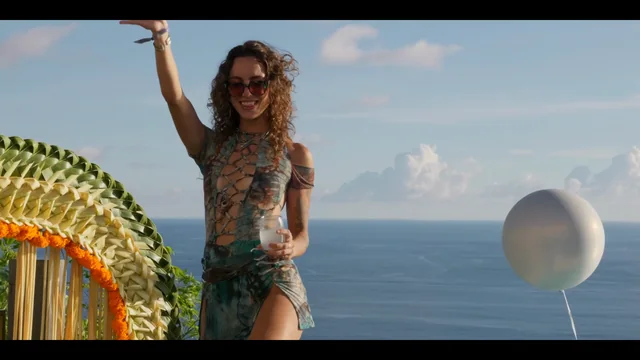 A guest with a drink above the ocean